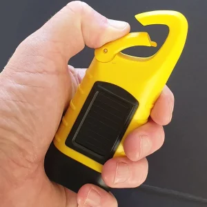 Yellow dynamo torch held in hand with carabiner clip open