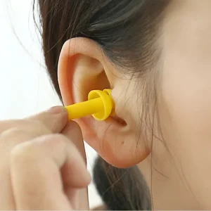 putting a yellow silicon ear plug into right ear