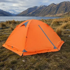 orange 4 season camping tent for 2 people used =next to a NZ lake