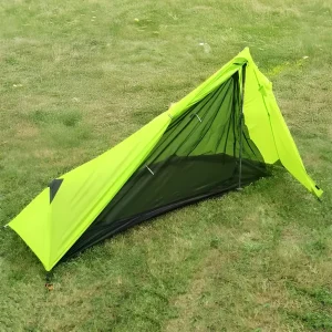 green ultralight hiking pole tent set up on the grass