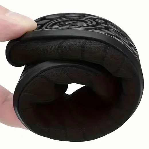 Black aqua water shoes folded by hand to demonstrate their flexible, compact construction