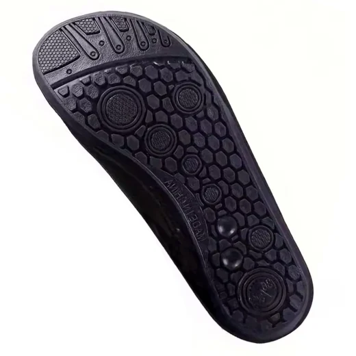 Close-up of the patterned sole on black aquatic water shoes with hexagonal and circular grip sections