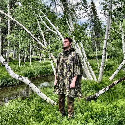 man wearing camo poncho without the hood