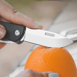 cutting an orange with a folding pocket knife blade