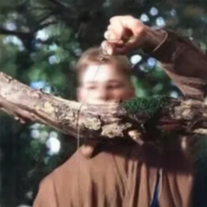 man cutting a branch with a wire saw