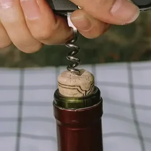 using a pocket knife corker to remove a cork from a bottle