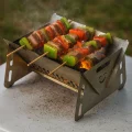 Portable mini BBQ grill for hiking showing orange glow from burning charcoal