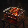Stainless steel mini BBQ grill for hiking with glowing coals at night