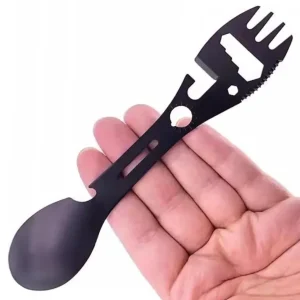 Black stainless multi tool spork held in a hand to show size and slim shape