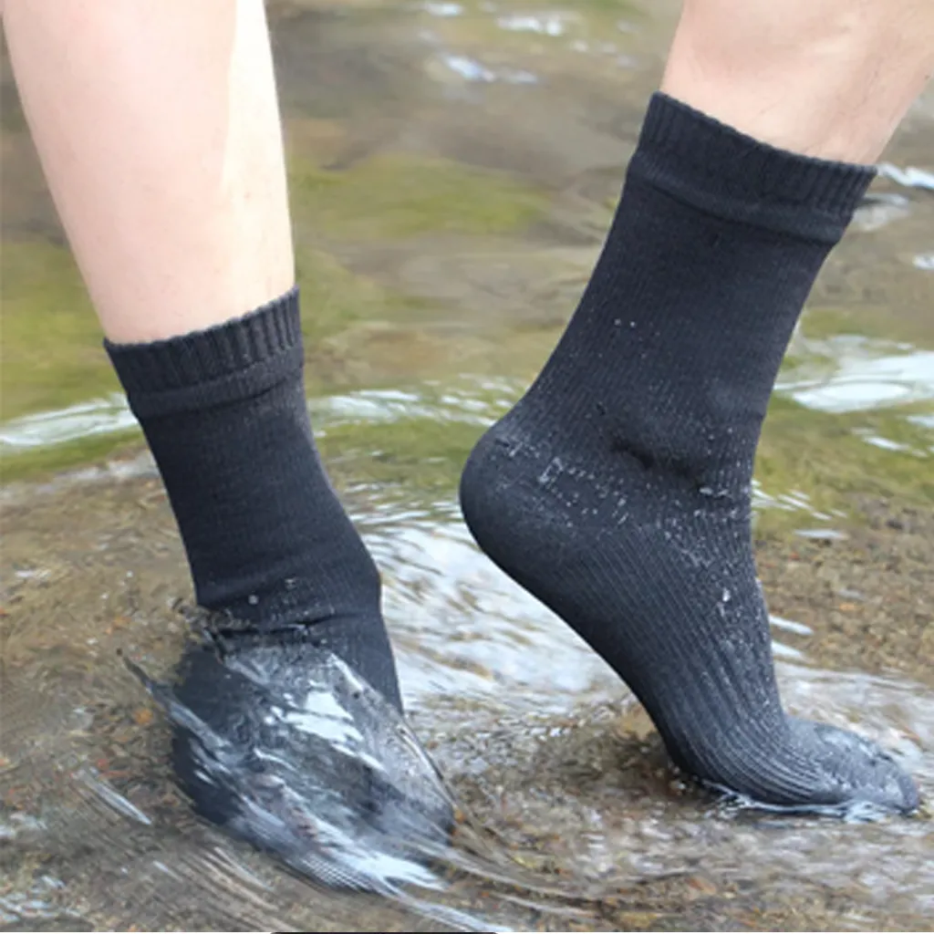 Close-up of black waterproof socks in shallow water during a stream crossing