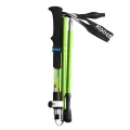 Green trekking pole folded compactly with black EVA handle, wrist strap, and visible locking clip