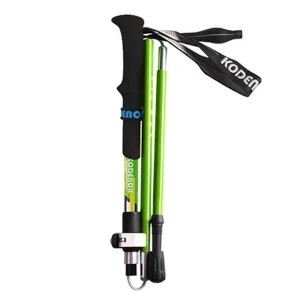 Green trekking pole folded compactly with black EVA handle, wrist strap, and visible locking clip
