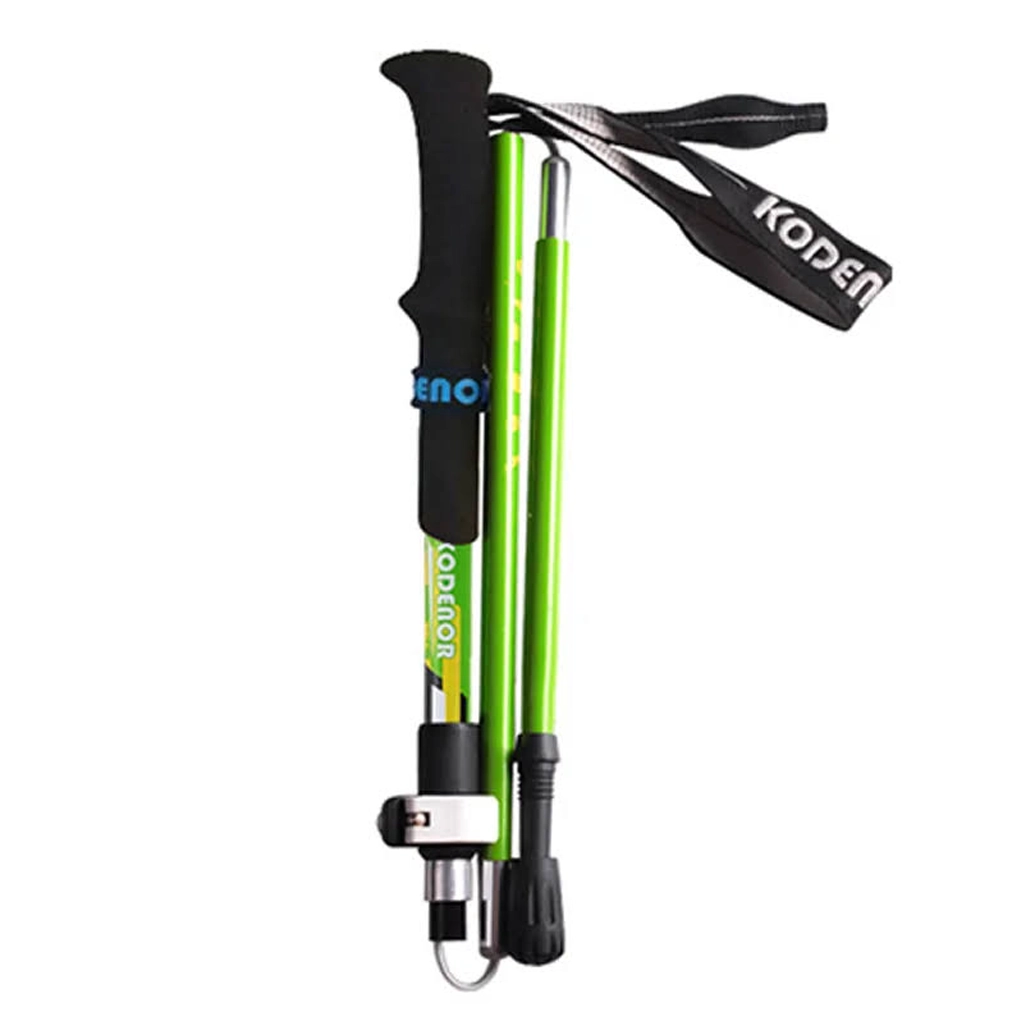Green trekking pole folded compactly with black EVA handle, wrist strap, and visible locking clip