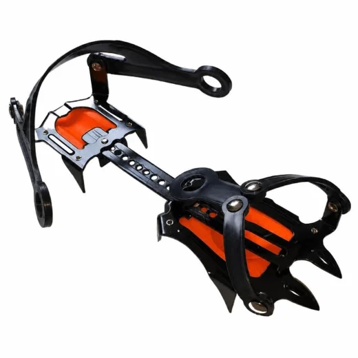 Angled top view of one orange and black strap-on crampon showing the front and rear harness loops