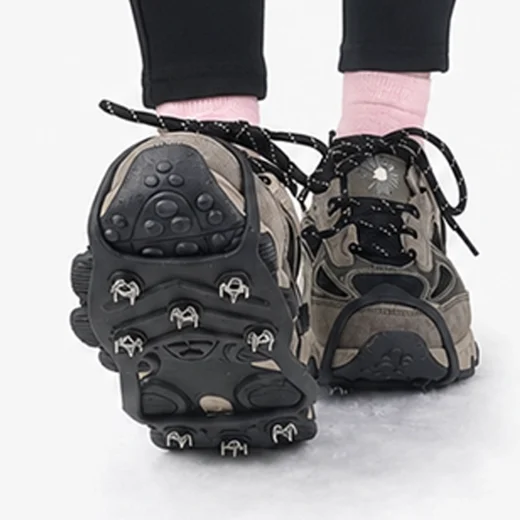 Hiking shoe raised to show the black traction grip and stud arrangement on snow