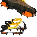 Orange and black 10 tooth crampons with yellow straps shown fitted beneath a hiking boot, with the pair displayed below