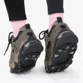 Rear view of black ice grips fitted to hiking shoes while walking on snow