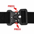 Black quick release belt buckle with arrows showing where to press the red release tabs