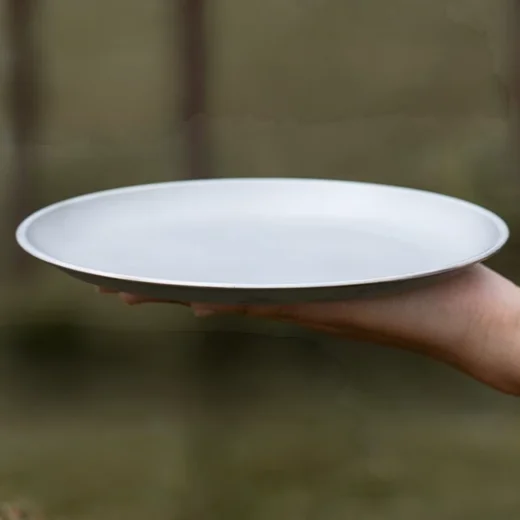 Side view of a lightweight camping plate showing its shallow raised rim